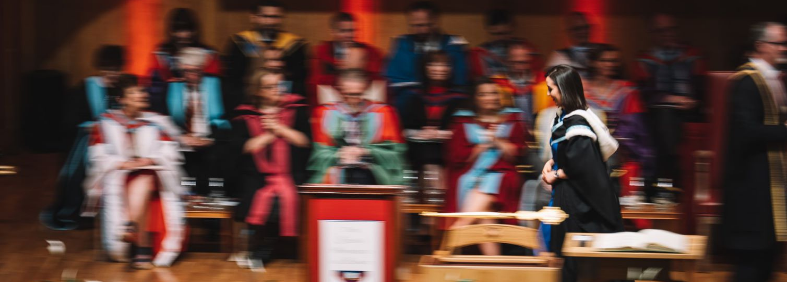 female graduate walking across stage during graduation ceremony