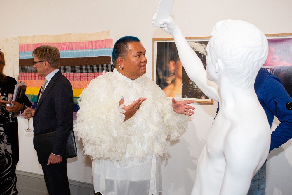 NGXX - Naughton Gallery 20th anniversary exhibition - artist talking with attendee in front of statue