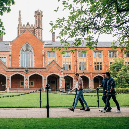 Staff and students walking across the Queen's quadrangle