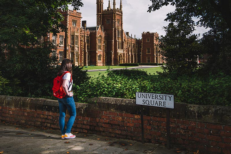 Girl with a backpack looks at Queen's