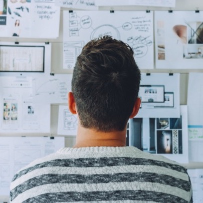 A man looks at a whiteboard filled with notes