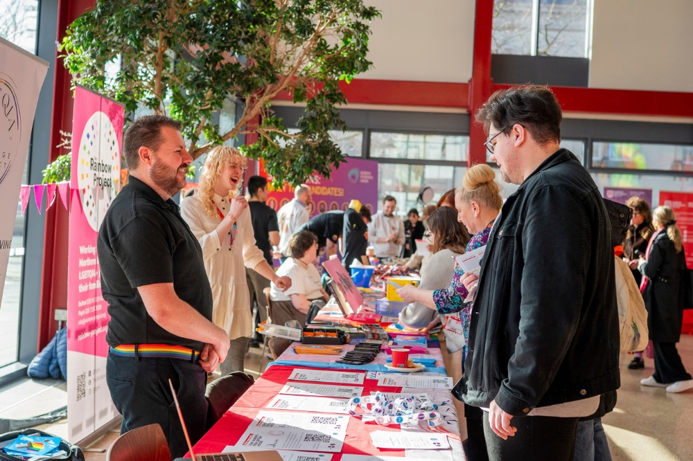 attendees of LGBTQueen's Celebration Showcase chatting to stall-holders