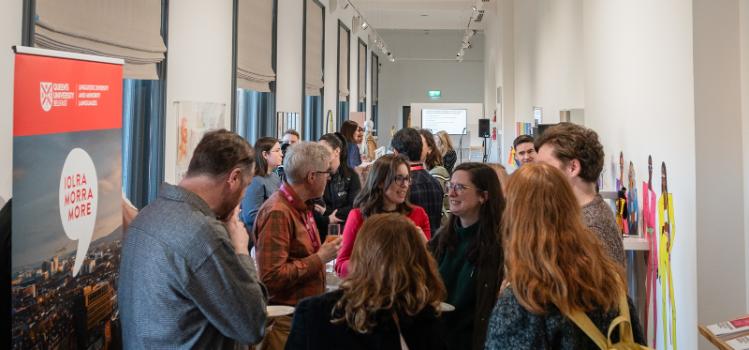 staff in conversation in the Naughton Gallery at the launch event for Iolra, Morra, More - Queen's new Staff Network for Promoting Linguistic Diversity and Minority Languages